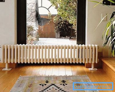 Na fotografiji je prikazan radiator, nameščen na tleh. Na fotografiji je prikazan radiator, nameščen na tleh.